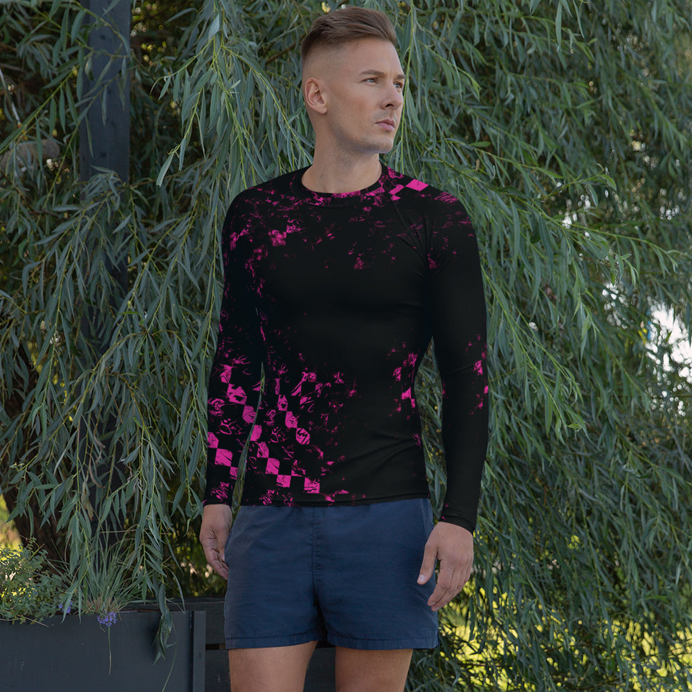Ein Mann trägt ein Rashguard mit dem Motiv Abstract Squares. Er steht vor Bäumen und schaut zur Seite.