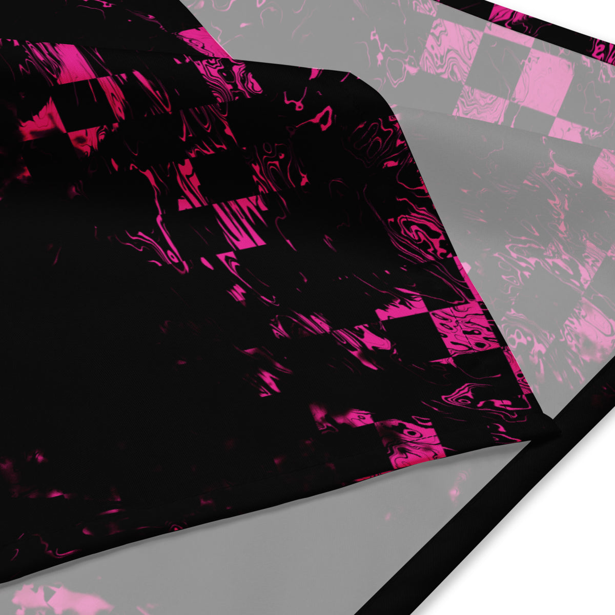 Bandana Abstract Squares von Bachblatt mit magentafarbenem Muster auf Schwarz – Nahaufnahme des gefalteten Stoffes mit Saum.