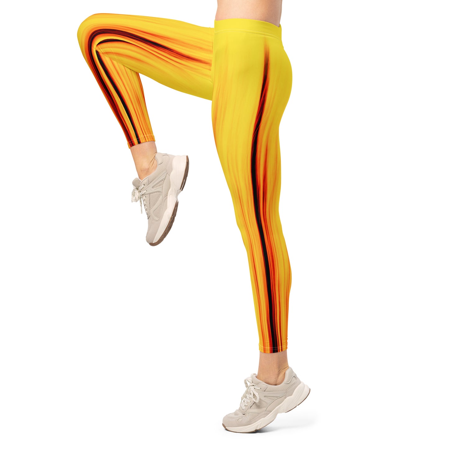 Eine Frau trägt die Moving Forest One Yellow Red Mid Waist Damen Leggings von Bachblatt und hebt ein Bein nach vorn. Ansicht von der Seite.